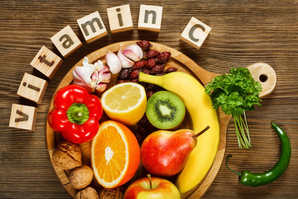 vitamin c written on the blocks and foods which are rich in vitamin c are placed in platter